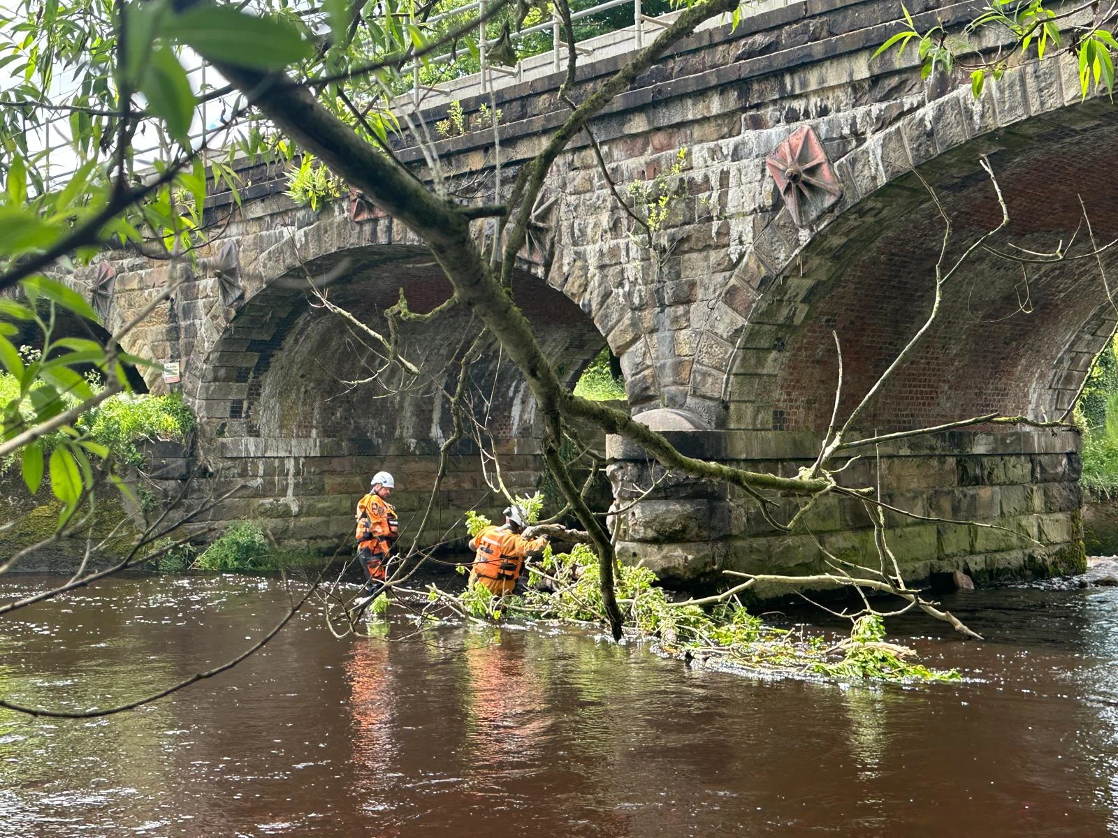 CRM operatives carrying out water-based works beneath a masonry bridge