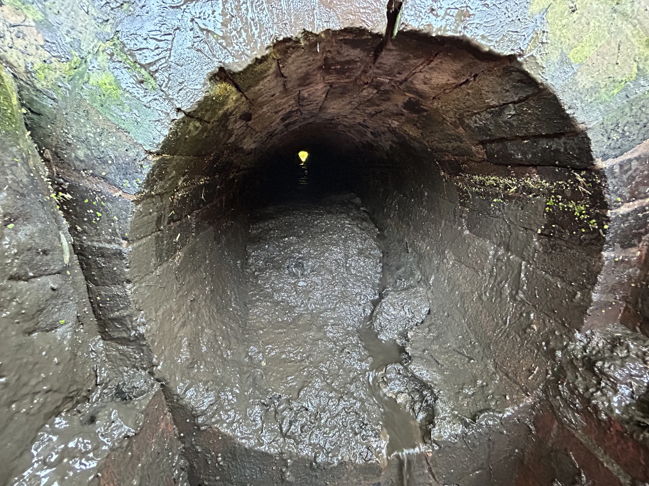 Heavily obstructed masonry culvert before clearance works